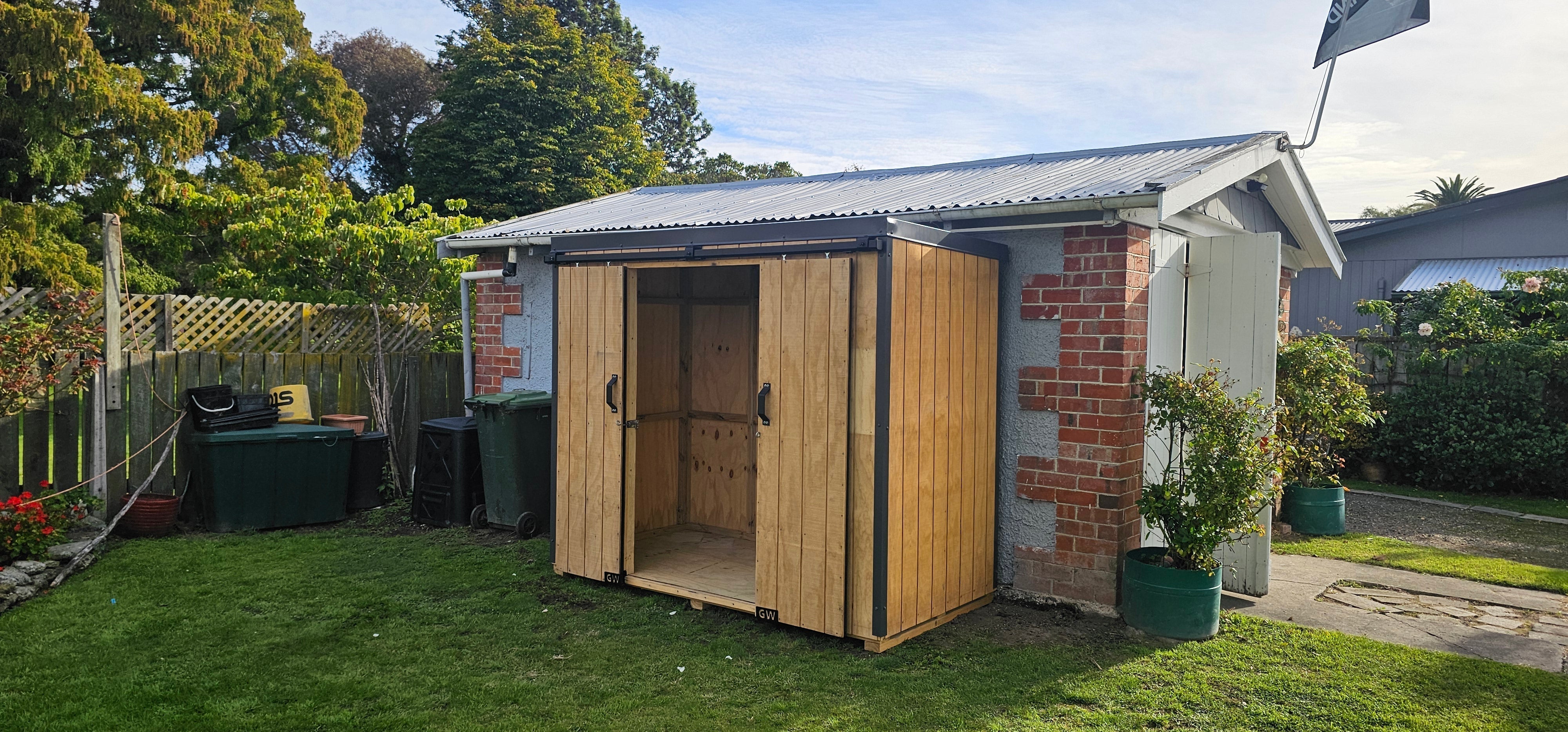 basic 2.4m shed installed next to a garage