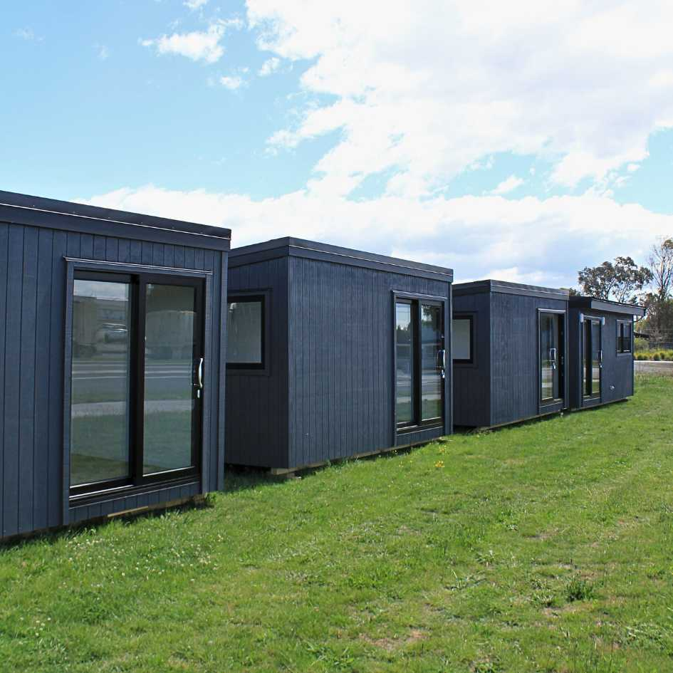 Four Goodwood cabins in a row on a lawn